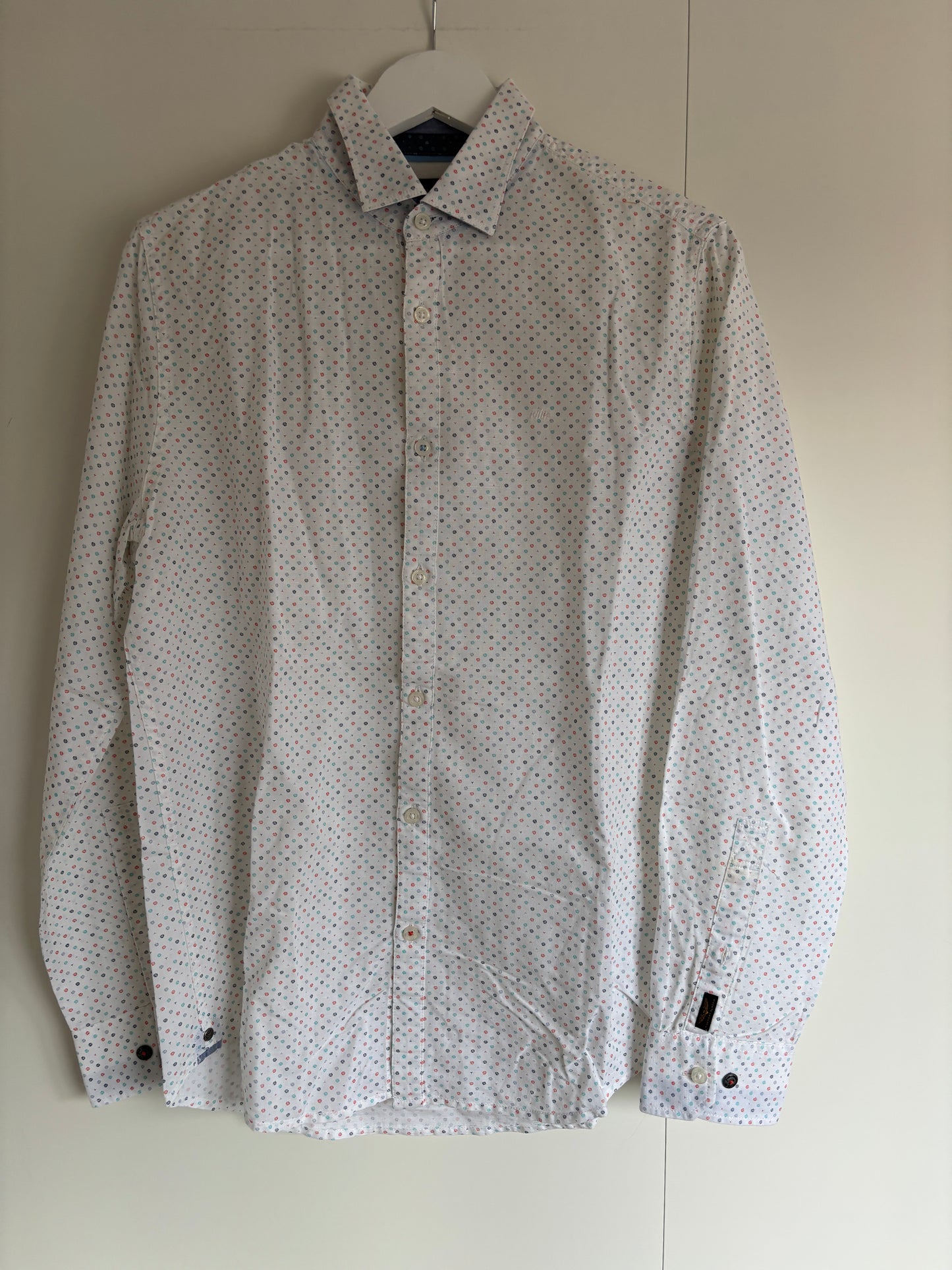 Wit hemd met gekleurde symbooltjes