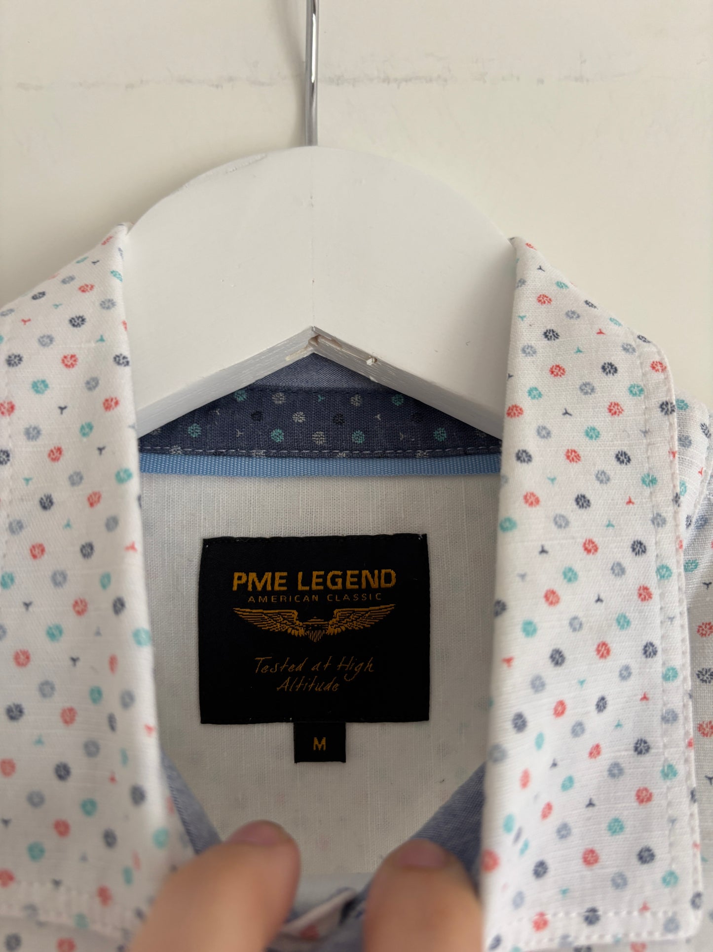 Wit hemd met gekleurde symbooltjes