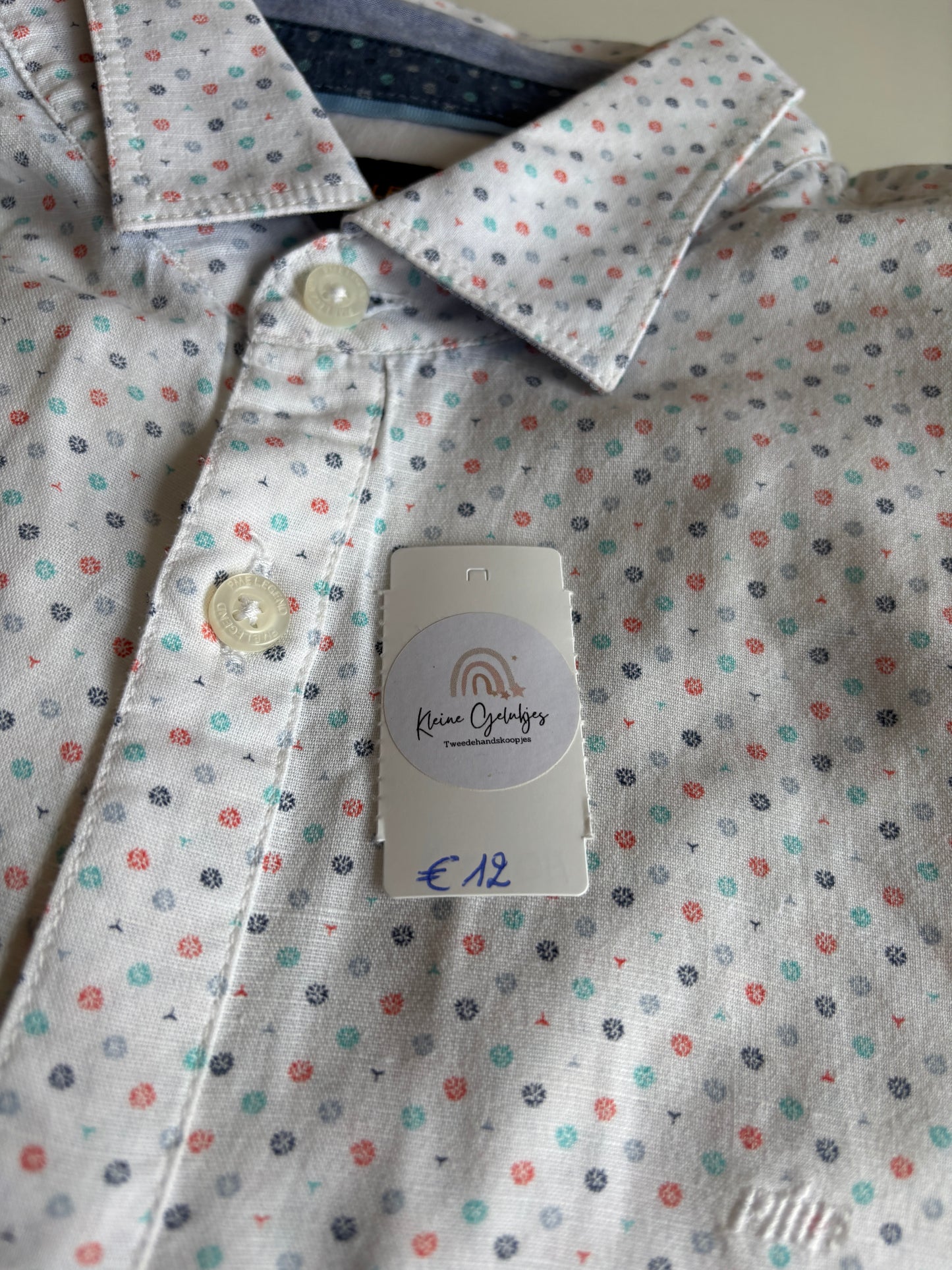 Wit hemd met gekleurde symbooltjes