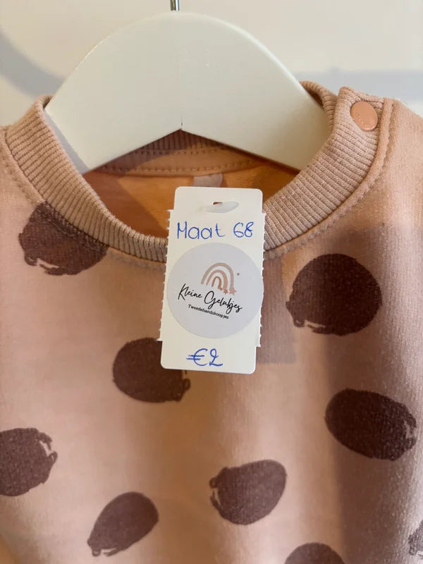 Pasteloranje sweater met bruine bollen